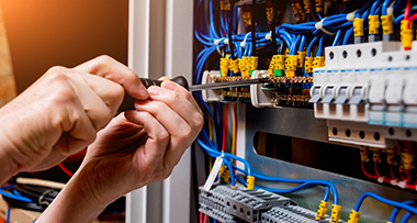 an electrician servicing a fuse box